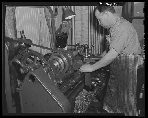 Conversion. Food machinery plant. Cutting of spouts for anti-tank guns is the present work of this lathe, shown here at its former job-shaping wooden rollers used with a belt control to carry steaks into the cube steak machine which is this New England plant's normal production. Conversion of this l