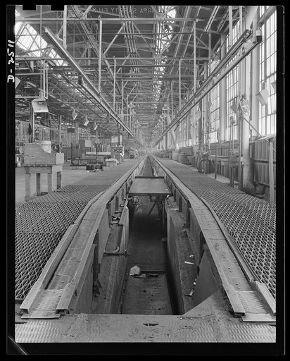 Conversion. Automobile industry. Only a short time ago ninety cars per hour were made on this assembly line. From the pit shown above, final inspection and installation of small parts on the bottom of the car were made. To prepare this plant for war production, the pit will have to be filled in. The