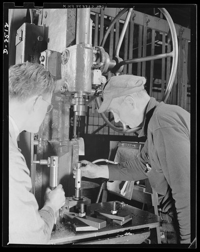 Conversion. Automobile industry. Installing new jogs and fixtures on an old automobile production machine. For more than ten years this machine has been making automobile parts; now it will make aircraft parts to help "keep 'em flying." The Plymouth Company, Chrysler Corporation, Detroit, Michigan