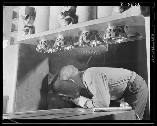 Conversion. Automobile industry. A welder prepares this giant machine for war work in a large Midwest factory now being converted from automobile to tank production. The Plymouth Company, Chrysler Corporation, Detroit, Michigan