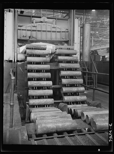 Conversion. Copper and brass processing. A mechanical feeder is here shown running billets of brass into an electric furnace, where they will be heated at a high temperature. Then the heated billets will be pushed with tremendous force through the die of an extrusion machine to form rods, tubes, ang