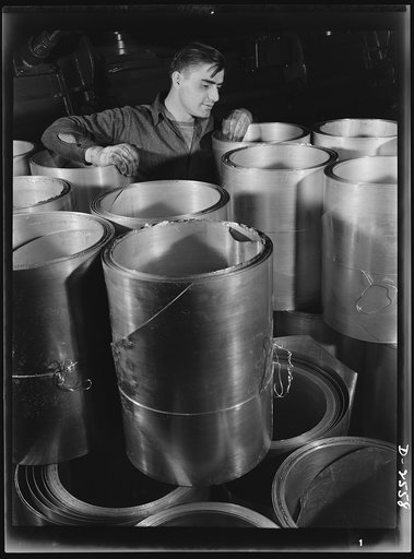 Conversion. Copper and brass processing. Large rolls of sheet brass and copper ready for the slitting machine, where the roll edges will be trimmed off. These unfinished rolls will all be slit into even-edged, uniform width rolls. Chase Copper and Brass Company, Euclid, Ohio