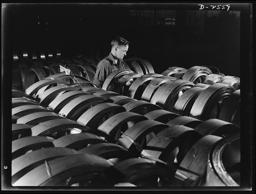 Conversion. Copper and brass processing. This is a stock of semi-finished strip copper in rolls. This metal will be rolled again later, to a thinner gauge. Then it will be cleaned, the edges smoothed and trimmed, and tied into neat coils for shipment. Chase Brass and Copper Company, Euclid, Ohio