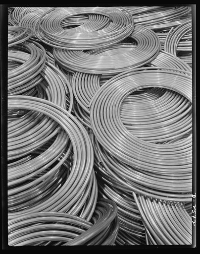 Conversion. Copper and brass processing. Coils of copper water tube. Large quantities of copper tube are needed by our Army and Navy, and vital industries. The smaller sizes are used for oil lines on equipment producing defense products and for fuel lines on tanks and other mechanized equipment. Sin