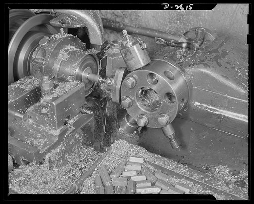 Conversion. Toy factory. Closeup of one of the hexagonal brass terminals in a screw machine recently converted to war production. Terminals are used for radio filter boxes in tanks and jeeps. Keystone