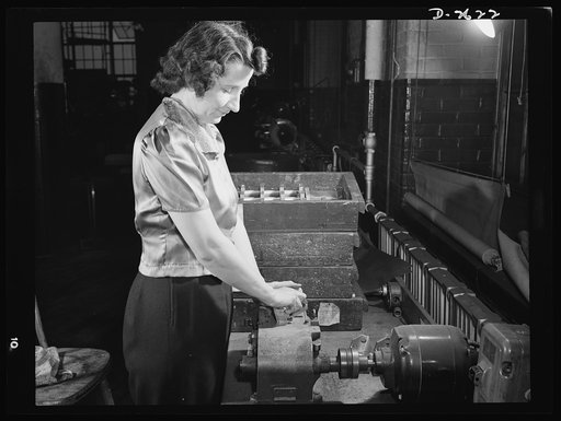 Conversion. Safety razor plant. Rita Allen sands V-blocks to remove marks made by milling machines. This razor factory has converted many of its machines to the production of tool posts which are essential to war production. Gillette