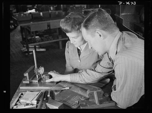 Conversion. Safety razor plant. Checking dimensions of completed V-block, shop supervisor George Cole explains testing processes to Edith Krause. Both these workers have graduated from razor blades to tool posts because of the company's subcontract for production of war tools
