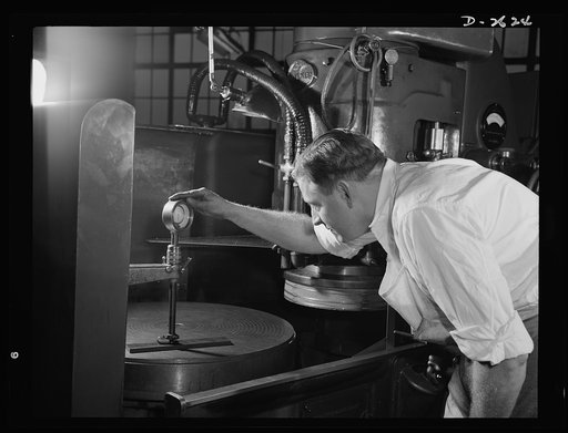 Conversion. Safety razor plant. He used to make razor blades, but now he's a vital cog in Uncle Sam's war production machine. Charles Taylor, inspects steel part on converted horizontal grinder. Gillette