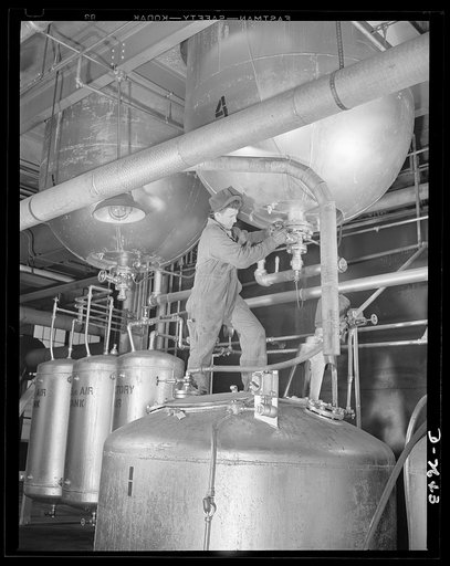 Synthetic rubber (Ameripol). This worker is standing on a "blowdown" tank, about ready to tap a polymerizer tank at the Akron, Ohio synthetic rubber plant of the B.F. Goodrich Company. The latex blended in the latter tank is stabilized in the "blow downs." A large blending tank increases the uniform