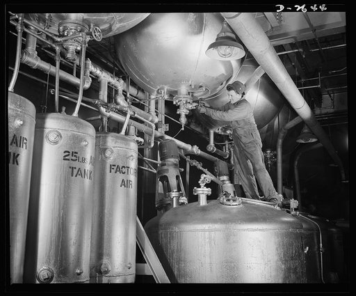 Synthetic rubber (Ameripol). This worker is standing on a "blowdown" tank, about ready to tap a polymerizer tank at the Akron, Ohio synthetic rubber plant of the B.F. Goodrich Company. The latex blending tank increases the uniformity of these synthetic solutions by mixing the contents of seven or ei