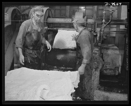 Synthetic rubber (Ameripol). These "crumbs" of synthetic rubber, free of water, are now being rolled into sheets. Goodrich