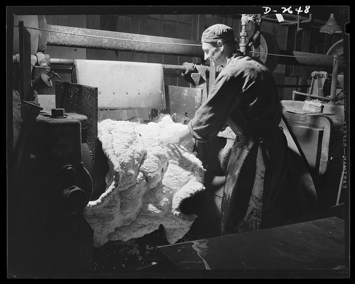 Synthetic rubber (Ameripol). These "crumbs" of synthetic rubber, free of water, are now being rolled into sheets. Goodrich