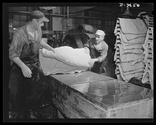Synthetic rubber (Ameripol). This is the cutting and trimming table, where newly-rolled sheets of synthetic rubber are cut to size for the drying pans. Goodrich