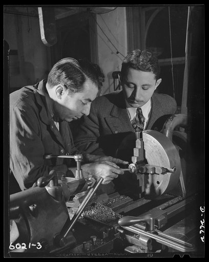Conversion. Frying pans to aircraft parts. Using a lathe converted from manufacture of egg poachers, frying pans and radio parts, this employee of a small Eastern plant is milling an aluminum alloy flap hinge forging to be used on American fighting planes. Precision Metal Company, New York, New York
