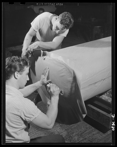 Self-sealing fuel tanks. These workers are applying covering to self-sealing tanks, an important safety development for military aircraft. Goodrich