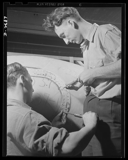 Self-sealing fuel tanks. These workers are installing the access door to a large self-sealing fuel tank for military aircraft. Goodrich