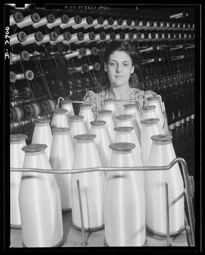 Fiberglass manufacture, Owens-Corning, Toledo, Ohio. Not bottles of milk, but bobbins of glass yarn. From the twisting frames where glass fiber is converted into fiberglass yarns of standard construction, the worker takes the all-glass material to the weaving department for fabrication into tapes an