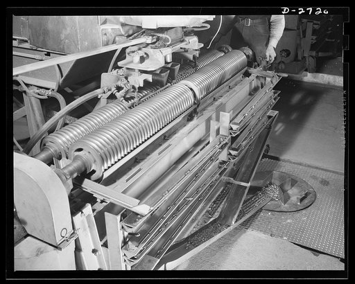 Fiberglass manufacture, Owens-Corning, Toledo, Ohio. This is the machine that forms clear glass marbles in a plant of the Owens-Corning Fiberglass Corporation. Marbles are fed as raw material into electric furnaces from which they are drawn into fibers one-twentieth the size of human hair