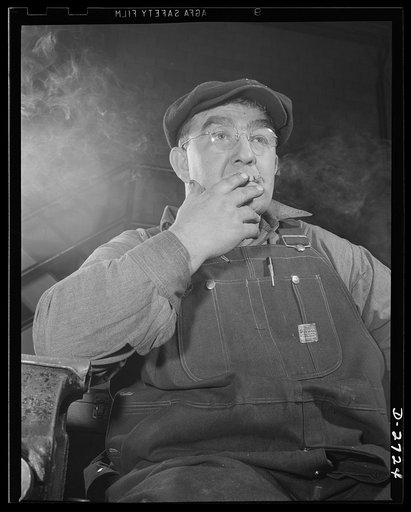 Fiberglass manufacture, Owens-Corning, Toledo, Ohio. A machine maintenance man in a plant of the Owens-Corning Fiberglass Corporation enjoys a smoke as he goes off the shift