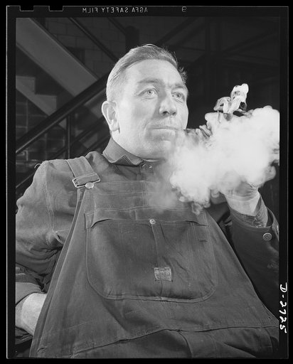 Fiberglass manufacture, Owens-Corning, Toledo, Ohio. A machine maintenance man in a plant of the Owens-Corning Fiberglass Corporation enjoys a smoke as he goes off the shift