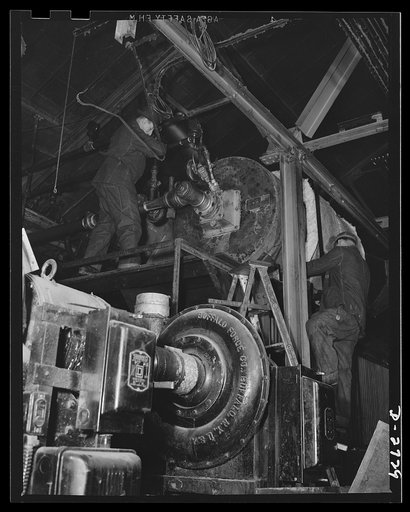 Fiberglass manufacture, Owens-Corning, Toledo, Ohio. Fiberglass metal mesh blankets made of glass fiber thermal insulation sandwiched between facings of metal mesh are being installed around a boiler in the powerhouse of a plant of the Owens-Corning Fiberglass Corporation