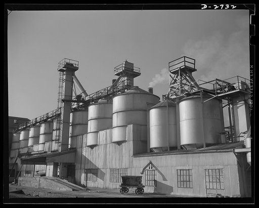 Fiberglass manufacture, Owens-Corning, Toledo, Ohio. Section of the batch house at a plant of the Owens-Corning Fiberglass Corporation. In the bins are stored the raw materials for the batch from which fiberglass materials vital to the war effort are produced