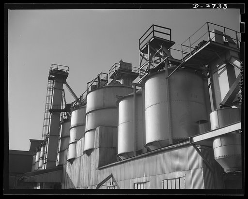 Fiberglass manufacture, Owens-Corning, Toledo, Ohio. Section of the batch house at a plant of the Owens-Corning Fiberglass Corporation. In the bins are stored the raw materials for the batch from which fiberglass materials vital to the war effort are produced