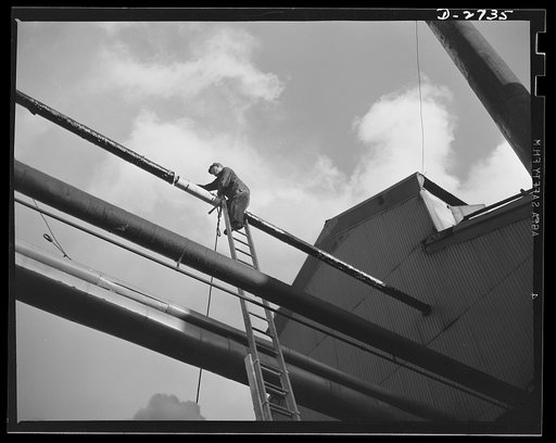Fiberglass manufacture, Owens-Corning, Toledo, Ohio. Like the chef who eats his own cooking, Owens-Corning Fiberglass Corporation uses its own fiberglass pipe covering. Here a maintenance man at one of the plants applies weatherproof paint to a section of high pressure steam piping. More than 200 mi