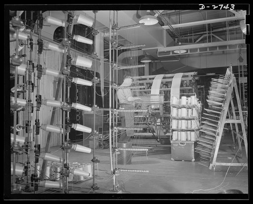 Fiberglass manufacture, Owens-Corning, Toledo, Ohio. Warp yarns of fiberglass are being paralleled on a beam preparatory to weaving all-glass fabrics