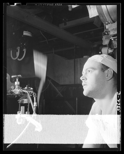 Fiberglass manufacture, Owens-Corning, Toledo, Ohio. Gossamer filaments of glass, each twenty times finer than human hair, are drawn together into a strand at more than a mile a minute, and wound on a forming tube on the floor below. The fibers are drawn from glass melted in an electric furnace abov