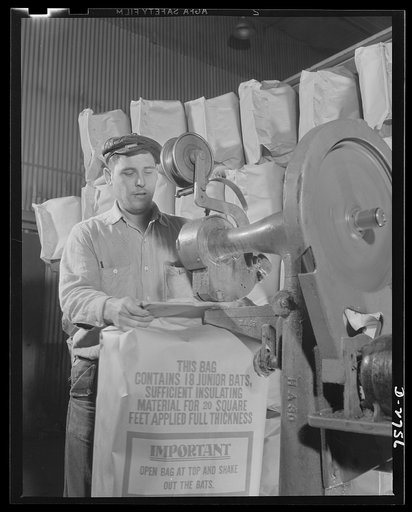 Fiberglass manufacture, Owens-Corning, Toledo, Ohio. A worker in a plant of the Owens-Corning Fiberglass Corporation is packaging bats of lightweight, inorganic, firesafe building insulation. Recent findings by the U.S. Bureau of Mines show that adequate home insulation can save over a billion dolla