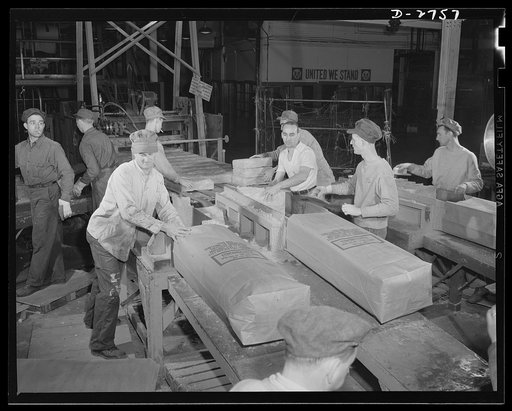 Fiberglass manufacture, Owens-Corning, Toledo, Ohio. A worker in a plant of the Owens-Corning Fiberglass Corporation is packaging bats of lightweight, inorganic, firesafe building insulation. Recent findings by the U.S. Bureau of Mines show that adequate home insulation can save over a billion dolla