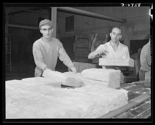Fiberglass manufacture, Owens-Corning, Toledo, Ohio. A worker in a plant of the Owens-Corning Fiberglass Corporation is packaging bats of lightweight, inorganic, firesafe building insulation. Recent findings by the U.S. Bureau of Mines show that adequate home insulation can save over a billion dolla