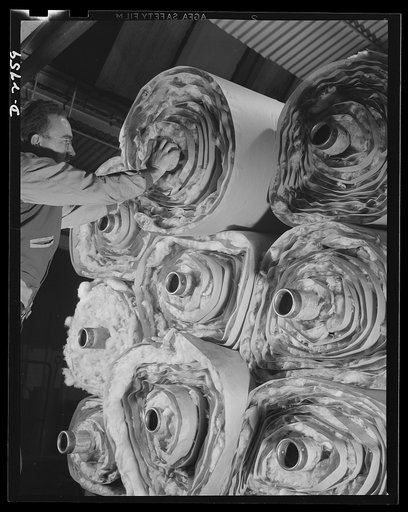 Fiberglass manufacture, Owens-Corning, Toledo, Ohio. Fiberglass thermal insulation is packaged in rolls and taken elsewhere in a plant to be fabricated into pipe covering or insulating blocks