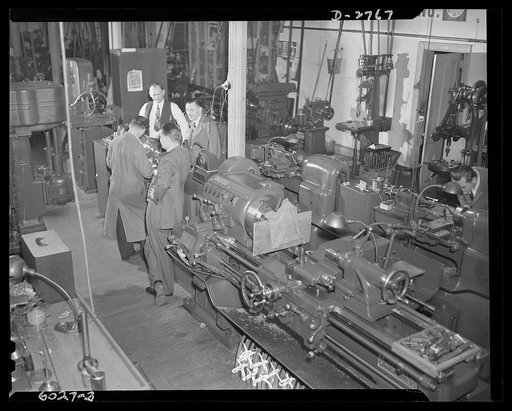Conversion. Soft drink dispenser plant. These machines are working for Uncle Sam instead of manufacturing such civilian items as soft drink dispensers and game boards. Inspecting operation of a tool room lathe are officials of this company which is producing tools for cartridge manufacture, brass qu