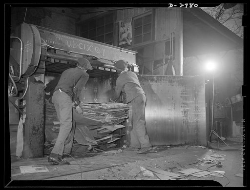 Scrap collection. A baling press being filed with cardboard from waste paper boxes. Washington, D.C. Shapiro Company, Baltimore, Maryland