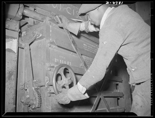 Scrap collection. The heavy door on the baling press is closed and locked. The door must be strong enough to withstand the terrific pressure which is exerted sideways as well as upward on the scrap paper inside. Shapiro Company, Baltimore, Maryland