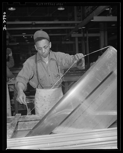 Conversion. Auto body plant. This Negro worker is dipping wing section of an airplane in bath, a necessary process prior to painting. Location: a large Midwest factory, recently converted from manufacture of automobile bodies to essential war production. Briggs Manufacturing Company, Detroit, Michig