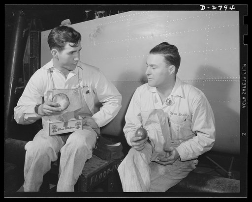 Conversion. Auto body plant. This business of wiping Hitler off the map is a job that calls for speed. Workers in a huge Midwest plant, newly converted from automobile body to airplane production, take time out for lunch right next to the job they're working on. Briggs Manufacturing Company, Detroit