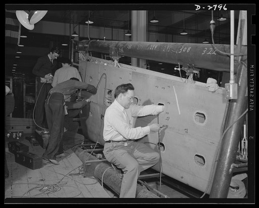 Conversion. Auto body plant. Assembling a wing section of airplanes in a factory newly converted to airplane production. Automobile bodies were formerly made here