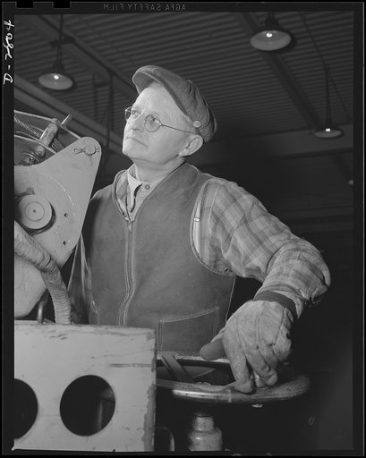 Conversion. Auto body plant. Driving his little electric scooter, this worker inspects progress of conversion to airplane production in a large Midwest automobile body manufacturing plant. Briggs Manufacturing Company, Detroit, Michigan