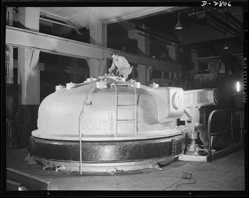 Giant tire manufacturer. Giant vulcanizer used in the vulcanization of bullet-sealing gasoline tanks, eight-foot high bomber tires and huge 3,600-pound earth mover tires. This unit at a large Eastern tire plant is the largest of its kind in the world. It must be thoroughly and constantly inspected a