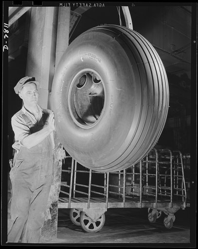 Giant tire manufacturer. This bomber tire has just been removed from a mold and is on its way to final inspection, where it will be thoroughly checked before becoming a part of Uncle Sam's fighting forces. Airplane tire production is going forward twenty- four hours a day, seven days a week in this 