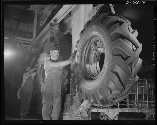 Giant tire manufacturer. A steady stream of large, rugged tires for Uncle Sam's fighting forces, like those above, is now in mass production at this large Eastern plant. Here workmen are shifting newly vulcanized tires to conveyor lines that will take them to final inspection department. They are th