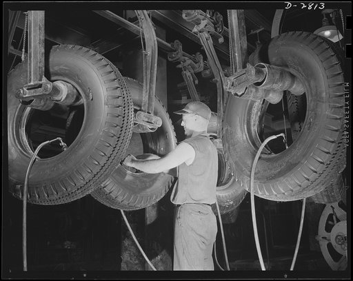 Giant tire manufacturer. Here a workman is drawing off steam from U.S. Army truck tires just removed from vulcanizing units at a large Eastern rubber plant. Once the steam is released from the air bags inside the tires, the tires will be moved on to the final inspection department before being shipp