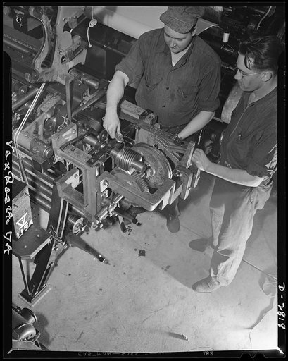 Conversion. Hosiery factory. These husky workers used to manufacture triple-sheer hosiery for Miss America. Today they're working for their Uncle Sam servicing mesh gears on a loom now producing mosquito netting for the Army and Navy. Van Raalte Company