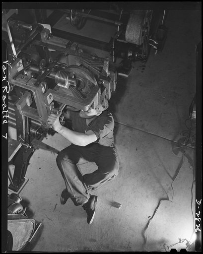 Conversion. Hosiery factory. This mechanic used to tend machines which produced some of America's sheerest hosiery. Today he's working for America's armed forces on these same machines, which are producing mosquito netting for the Army and Navy. In the picture, he's servicing the mesh gears of a loo