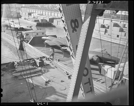 Lease lend loadings. Awaiting shipment across the sea on a lend-lease basis, these twin-engine light Douglas bombers are ready to be hoisted from barge to deck