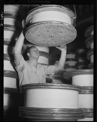 Transformer manufacture. Forming the heart of the giant transformers which manufacture power for America's war production plants, these spools of copper wire are lifted by a crane, guided into place by a worker. Westinghouse, Sharon, Pennsylvania