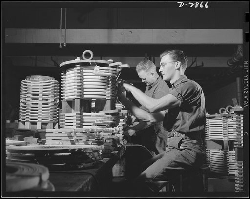 Transformer manufacture. Men with nimble fingers make good coil winders. These two employees of a large Eastern electrical company are producing transformers essential to war industries. Westinghouse, Sharon, Pennsylvania
